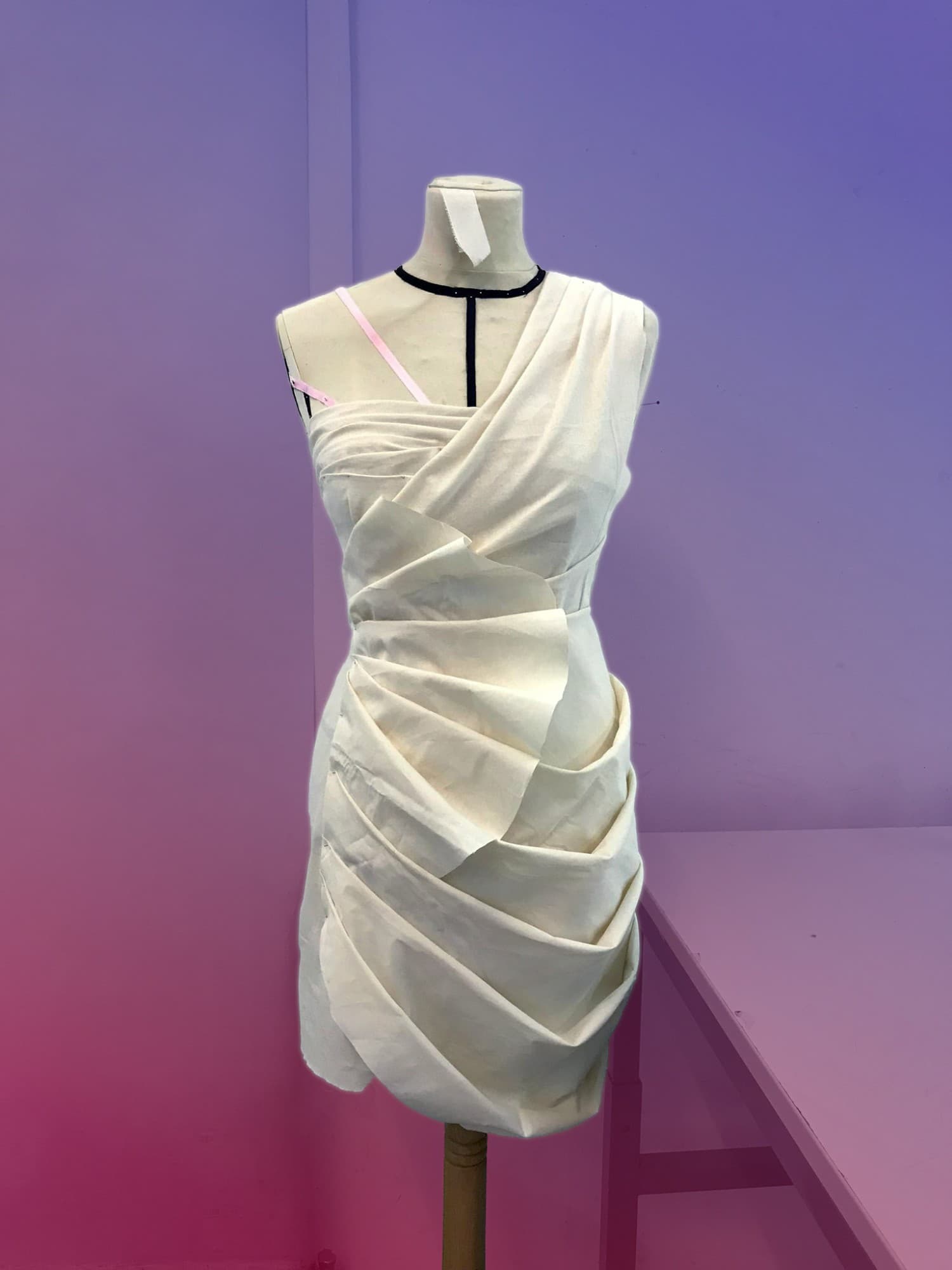 Robe drapée blanche montée sur un buste, en atelier